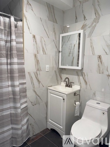 A bathroom with a toilet, sink, and shower curtain.