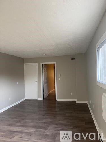 A room with wooden flooring and a white ceiling.