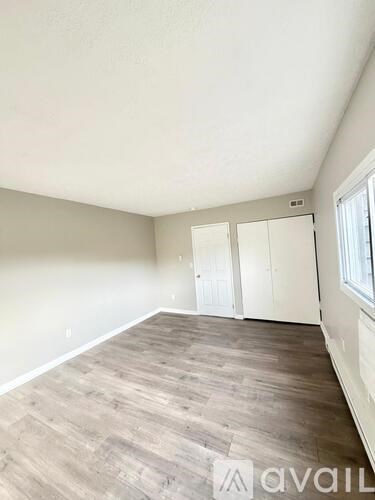 A room with wooden flooring and white walls.