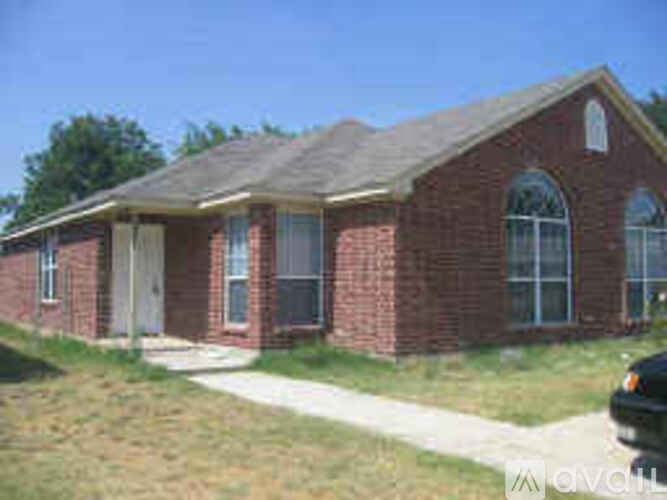 A small brick house with a white door and windows.