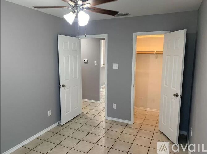 A room with a ceiling fan and tile flooring.