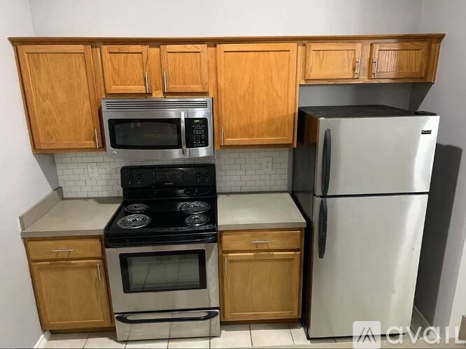A kitchen with wooden cabinets and a black stove top oven.