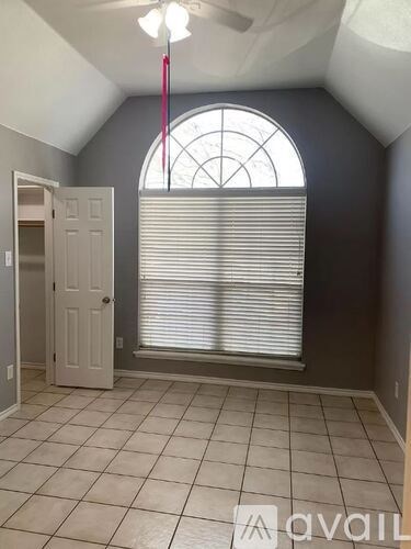 A room with a large arched window and a door.