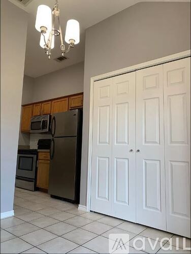 A kitchen with a refrigerator, microwave, and oven.