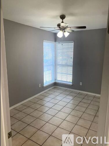 A room with a ceiling fan and tiled floor.