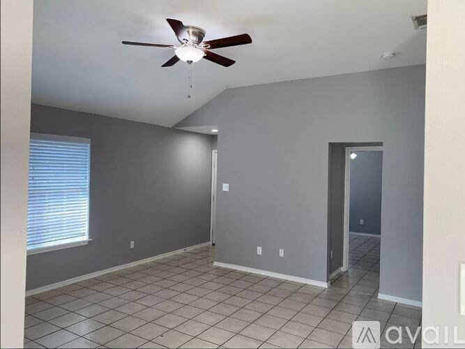 A room with a ceiling fan and tile flooring.