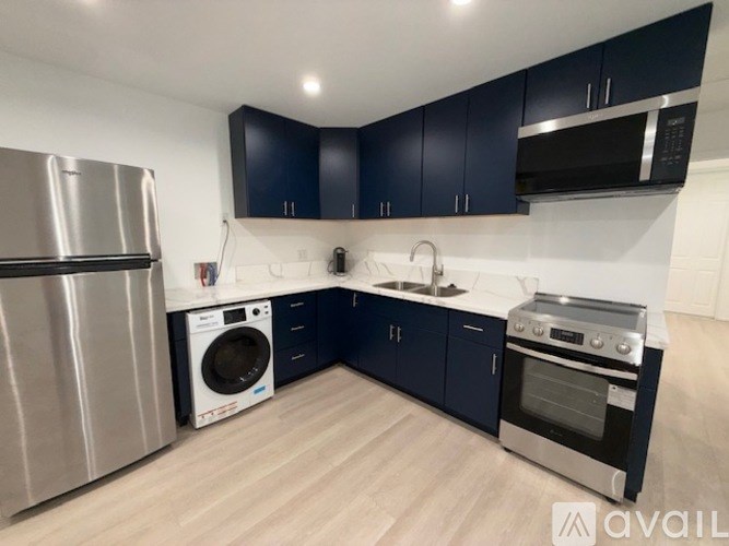 A kitchen with dark blue cabinets and stainless steel appliances.