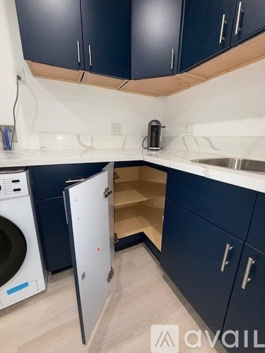 A kitchen with dark blue cabinets and a white countertop.