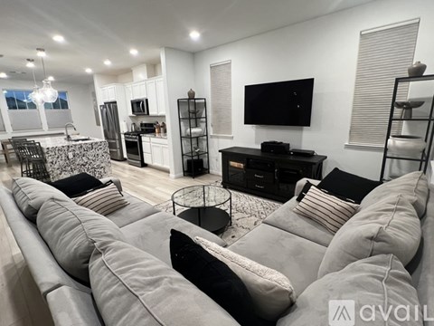 A modern living room with a grey sofa and a black television.