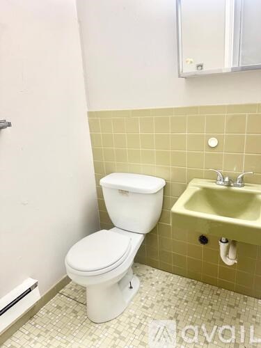 A white toilet sits next to a yellow sink in a bathroom.