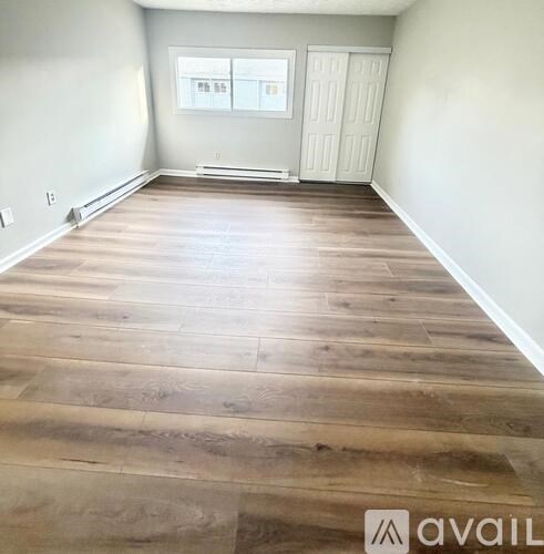 A room with wooden flooring and a white door.