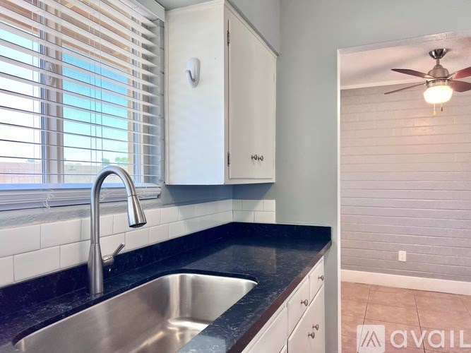 A kitchen with a sink and a fan.