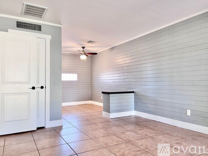 A room with a white door and a tiled floor.