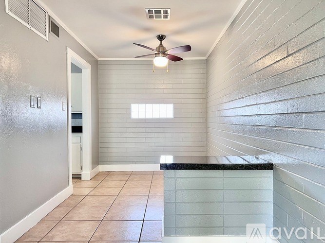 A room with a ceiling fan and a window.