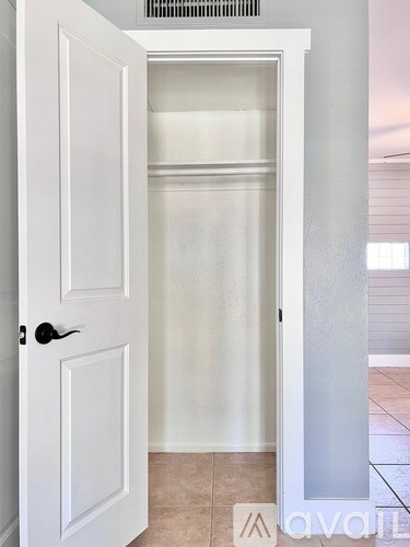 A white door with a black handle is open.