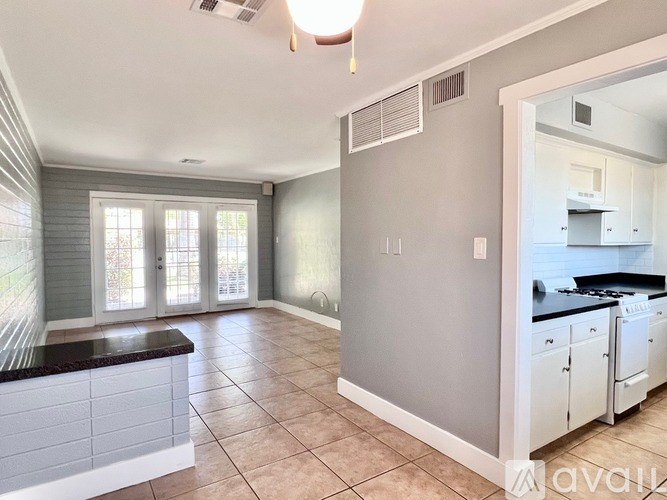 A kitchen with white cabinets and a tiled counter.