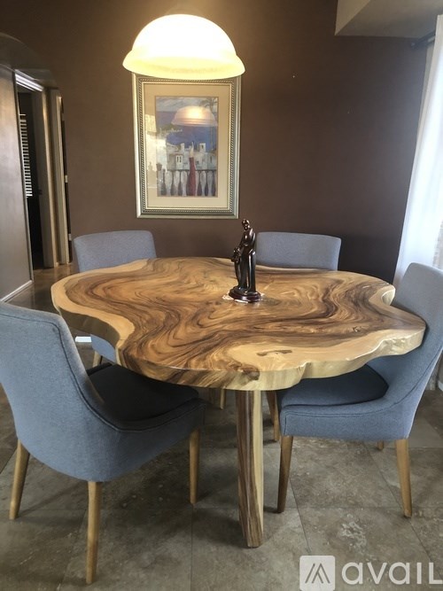 A wooden table with a lamp and a painting on the wall.