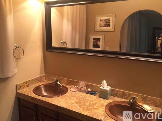 A bathroom with a brown sink and a mirror above it.