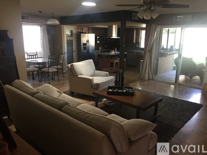 A living room with a couch, chairs, and a coffee table.