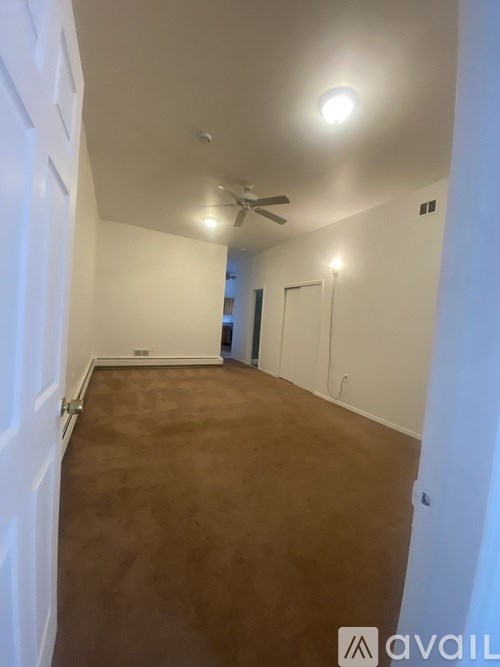 A room with a brown floor and white walls.