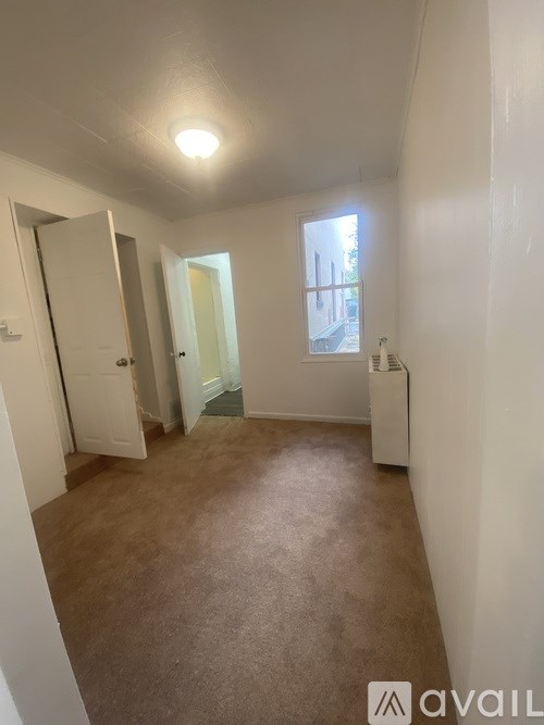 A room with a brown carpet and white walls.