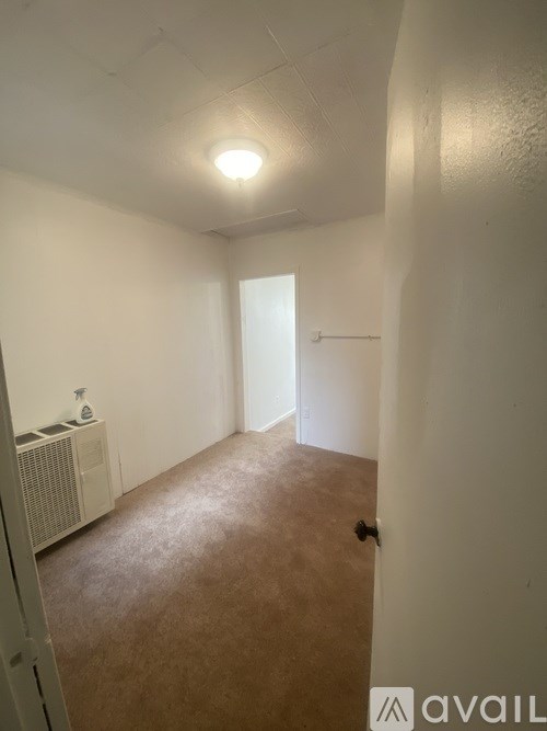 A room with a brown carpet and white walls.