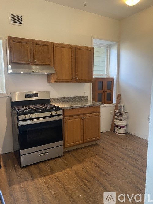 A kitchen with wooden cabinets and a stainless steel oven.