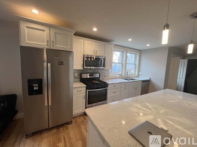 A kitchen with a refrigerator, oven, and microwave.