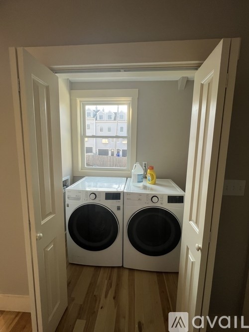 A washing machine is sitting in a small laundry room.