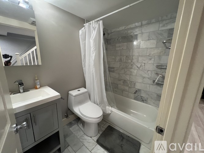 A bathroom with a toilet, sink, and bathtub.