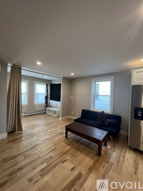 A living room with a couch, a coffee table, and a television.