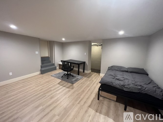 A room with a bed, desk, and chair.