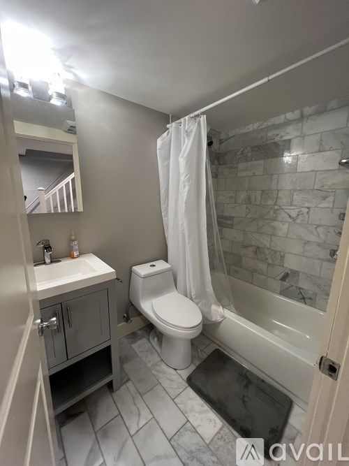 A bathroom with a toilet, sink, and bathtub.