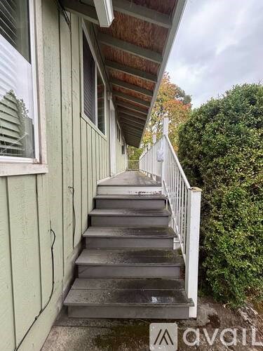 A staircase with a railing leading up to a door.