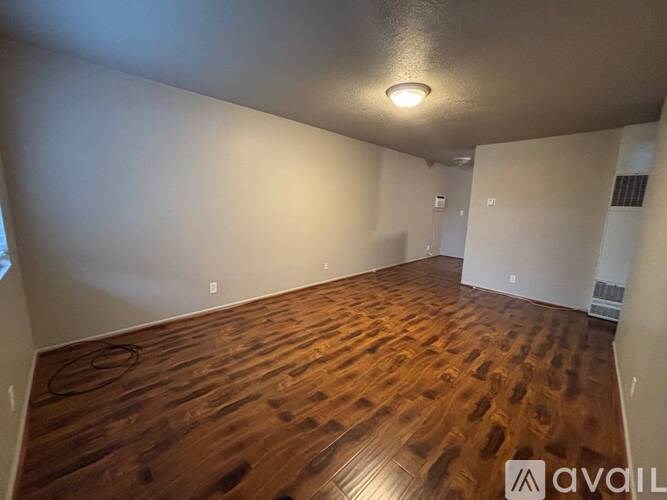 A room with wooden flooring and a ceiling light fixture.