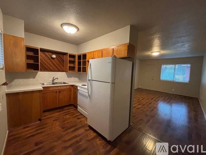 A kitchen with wooden cabinets and a white refrigerator.