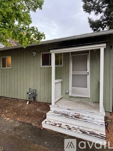 A small house with a porch and a door.