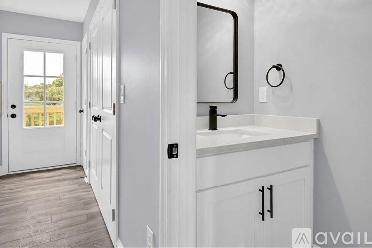 A bathroom with a white sink and a mirror.