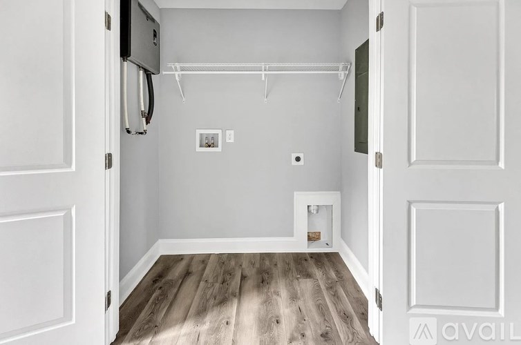 A white door with a small picture on the wall and a white shelf with a small box on it.