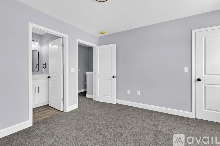A room with a carpeted floor and a ceiling fan.