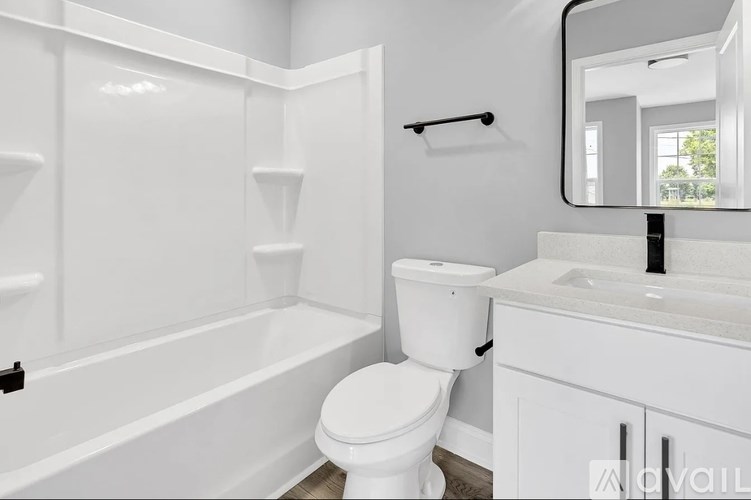 A white bathroom with a toilet, sink, and bathtub.