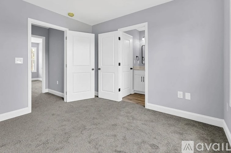 A room with a grey carpet and white doors.