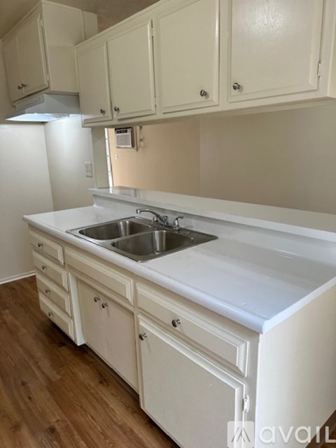 A kitchen with white cabinets and a white countertop.
