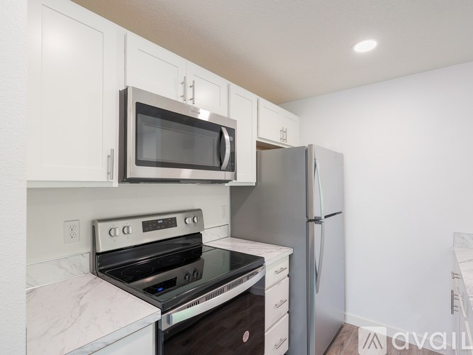 A kitchen with a stove, oven, microwave, and refrigerator.
