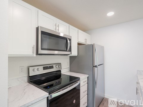 A kitchen with a stove, oven, microwave, and refrigerator.