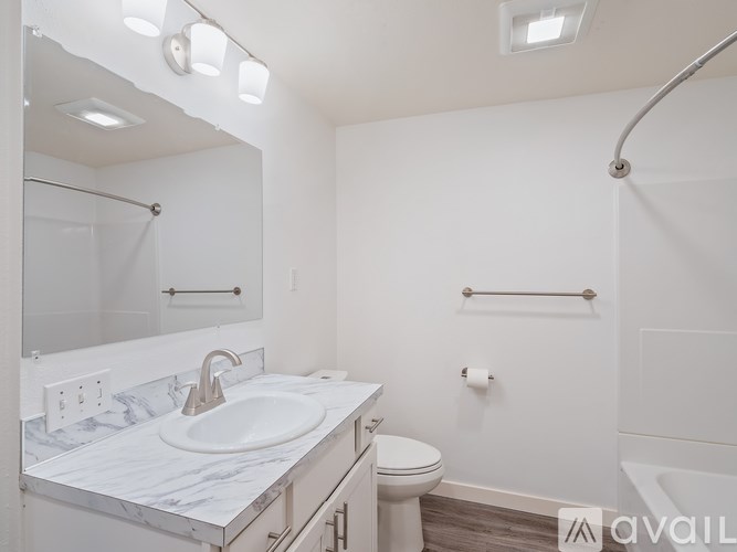 A bathroom with a marble countertop and a white sink.