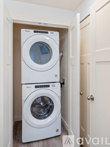 Two white front loading washing machines in a small laundry room.