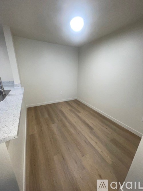 A room with wooden flooring and a white wall.