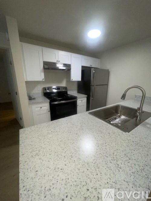 A kitchen with a granite countertop and stainless steel appliances.
