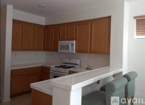 A kitchen with brown cabinets and white appliances.